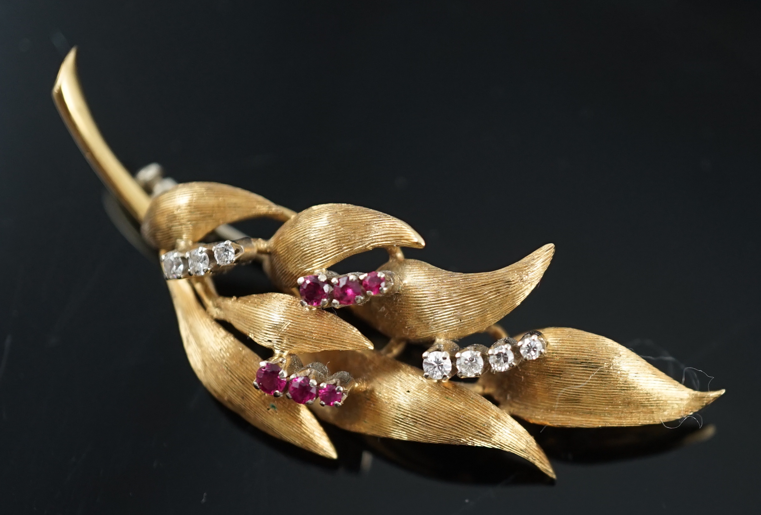 A 1960's 18ct gold, six stone ruby and seven stone diamond chip set leaf spray brooch